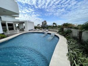 a swimming pool in front of a house at Equipetrol Depto 1 Dorm piso 12 in Santa Cruz de la Sierra