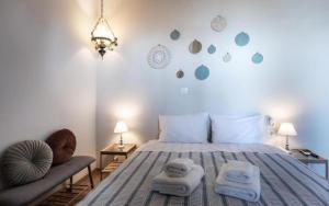 a bedroom with a bed with towels and a chair at Stagiates Guest House at Pelion in Portaria