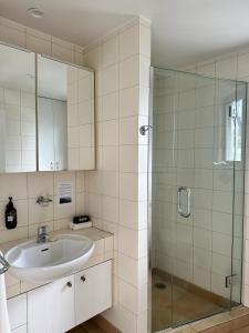 a bathroom with a sink and a glass shower at Beachfront on Waiheke in Onetangi +9 photos