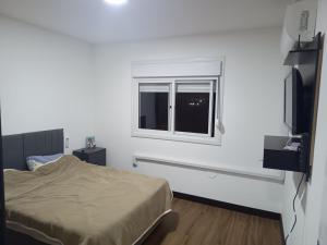 una stanza bianca con un letto e una finestra di Este espaço está disponível somente para locação anual a Canoas