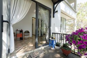 Un porche cubierto con plantas y flores. en Bit by Bit Villa - Venuestay, en Ấp Lat