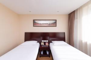 Postel nebo postele na pokoji v ubytování Golden Inns Chain Hotel Beijing JianGuomen 金泰之家北京站店