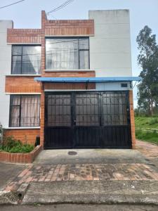 a house with two garage doors in front of it at La casaaa de Majo in Paipa