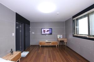 a living room with a tv on a wall at Uljin Blue Ara B pension in Uljin