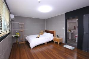 a bedroom with a teddy bear sitting on a bed at Uljin Blue Ara B pension in Uljin