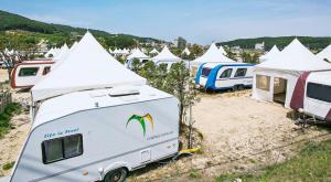 a group of tents and a caravan parked in a field at inceon wangsanotokaempingjang in Incheon