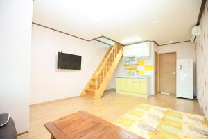 a living room with a staircase and a kitchen at Suncheon Bay Wind Hill House in Suncheon