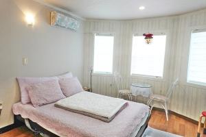 a bedroom with a bed and a table with chairs at Pyeongchang Jayeonel Dalmeunjip in Pyeongchang