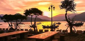 einen Sonnenuntergang über einem Wasserkörper mit Booten in der Unterkunft Geojae Beach Maru Pension in Geoje