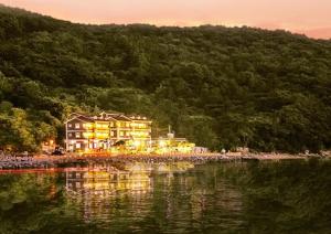 ein Gebäude am Ufer eines Wasserkörpers in der Unterkunft Geojae Beach Maru Pension in Geoje