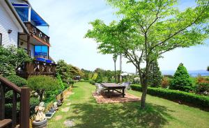 a yard with a picnic table and a tree at Anmyeondo Dream Pension in Taean