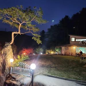 a bench in front of a house at night at poceon ciyuyisup pensyeon in Pocheon