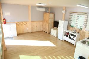 a kitchen with white cabinets and a refrigerator at poceon ciyuyisup pensyeon in Pocheon