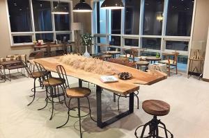 une grande table en bois dans une pièce avec des chaises dans l'établissement Seogwipo Okra Resort, à Seogwipo