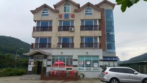 a building with a car parked in front of it at Yeosu Court Pension in Yeosu