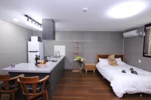 a room with a bed and a kitchen with a counter at Uljin Blue Ara CD pension in Uljin