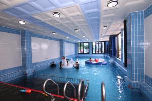 a pool with people in inflatable tubes in a room at Uljin blue ara A pension in Uljin