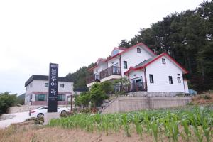 a house with a sign in front of it at Uljin blue ara A pension in Uljin