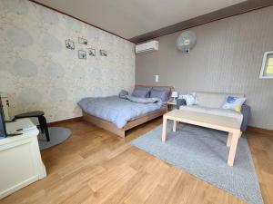 a bedroom with a bed and a couch and a table at Pocheon Haneulbat Pension in Pocheon