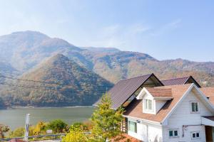 a house with a view of a river and mountains at Moojoo Jeonmangdae Pension in Muju