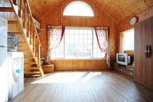 a large room with a staircase and a window at Moojoo Jeonmangdae Pension in Muju