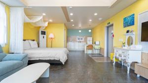 a bedroom with a bed and a living room at Namhae Healing Time Pension in Namhae