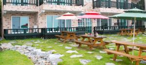 a group of picnic tables and umbrellas on a patio at Ulsan Lighthouse Pension in Ulsan