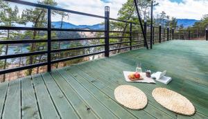 a table with a drink and a plate of fruit on a balcony at Gurye Jirisan Hosu Resort Pension in Gurye