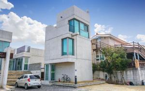 a house with a car parked in front of it at Tongyeong Monofunny Pension in Tongyeong +4 photos