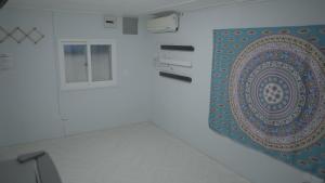 a rug hanging on a wall next to a window at Gapyeong Gumuchon Amusement Park Pension in Gapyeong