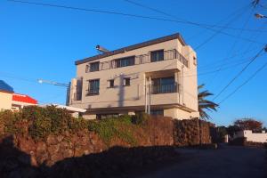 a white building with a fence in front of it at Seutei Hyeobjae10Gil in Jeju