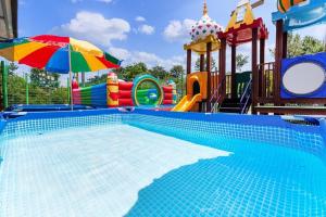 a large swimming pool with a playground and an umbrella at Taean Seesong Pension in Taean