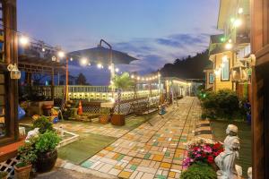 Un patio iluminado con flores y luces. en Taean Seesong Pension, en Taean