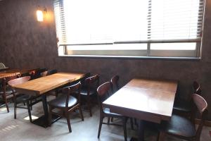 a restaurant with wooden tables and chairs and a window at Prince Hotel in Goseong