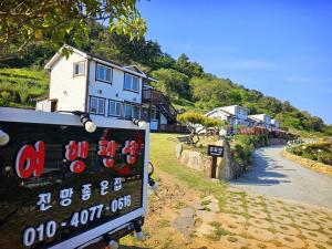 a sign in front of a house on a hill at Jeonnam Cheongsando Yeohaeng Pension in Wando