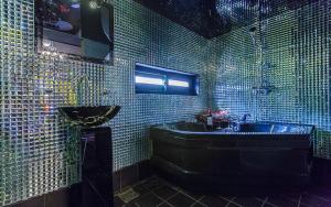 a green tiled bathroom with a tub and a sink at Chuncheon Pier Star Pension in Chuncheon +3 photos