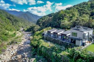 a house on a hill next to a river at Hadong Cloud Hill Pension in Hadong