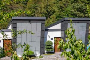 a house with two garage doors and a tree at Hadong Cloud Hill Pension in Hadong