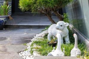 a statue of a sheep and swans in the grass at Hadong Cloud Hill Pension in Hadong
