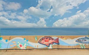 a wall with fish painted on it next to the ocean at gocang nemoyiggum in Gochang  +1 photo