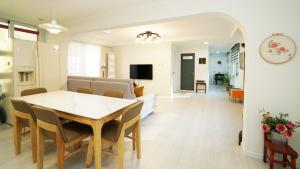 a dining room and living room with a table and chairs at Gangchon Nutinamu Maeul Pension in Chuncheon