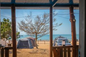 two tents on the beach with the ocean in the background at Bakripo Badawa Padosori Camping pension in Taean