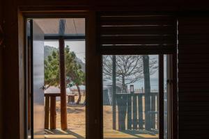 an open door with a view of a beach through a window at Bakripo Badawa Padosori Camping pension in Taean +16 photos