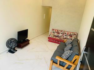 un soggiorno con divano e TV a schermo piatto di Casa com Piscina no litoral norte a Bertioga