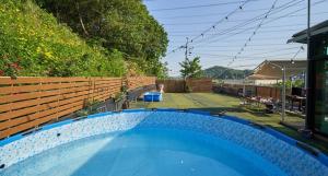 a swimming pool in a backyard with a fence at Daeboodo Podohyangki Pension in Ansan