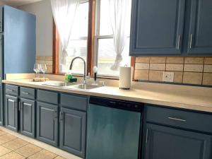 a kitchen with blue cabinets and a sink and a window at The Urban Oasis in Berwyn +11 photos