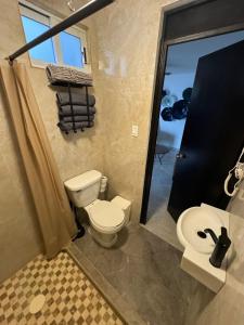 een badkamer met een wit toilet en een douche bij Casa margarita in La Paz +2 foto's