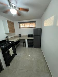 een keuken met een zwarte koelkast en een fornuis bij Casa margarita in La Paz +2 foto's