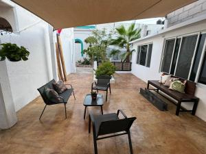 een woonkamer met stoelen, een bank en tafels bij Casa margarita in La Paz