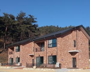 a large brick building with windows and a balcony at Yangyang Stay in Bricks in Yangyang
